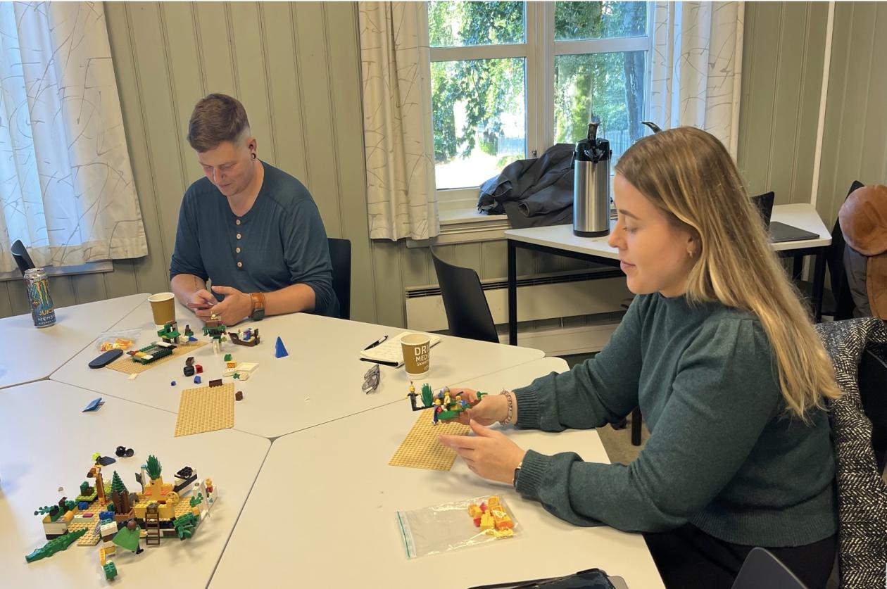 Bildet viser to av forskergruppens medlemmer, Christian og Marianne, som tester ut et opplegg der Lego brukes som et verktøy i tillitsbygging og som inngang til å arbeide med kontroversielle tema.