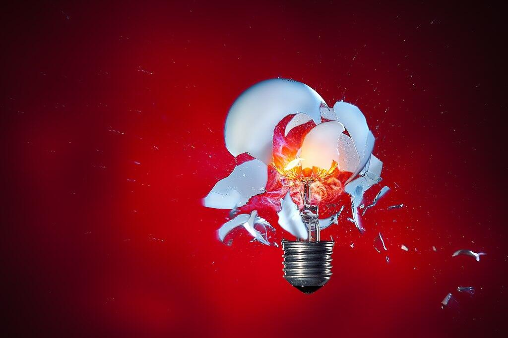  A light bulb exploding against a red colored background