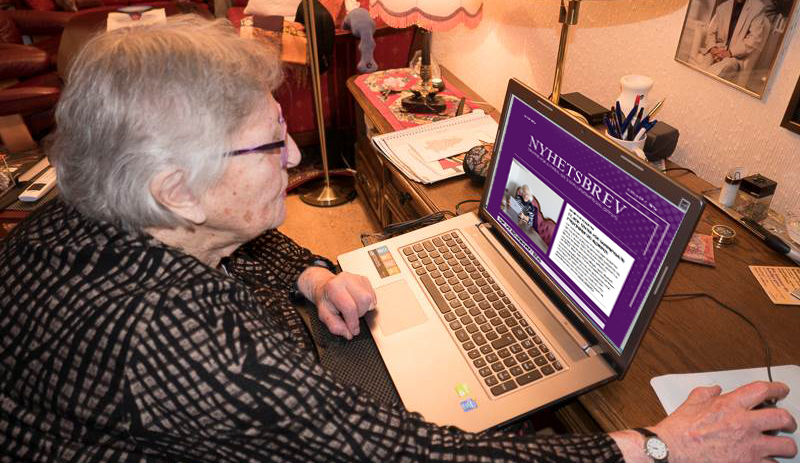 En gammel dame som leser SEFAS' nyhetsbrev på laptopen sin.