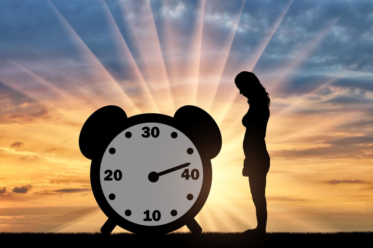 A woman standing by a clock