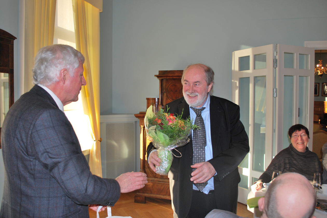 Prodekan ved HF, Einar Thomassen (t.v.), overrekker Anders Bjørkelo en bukett med blomster.