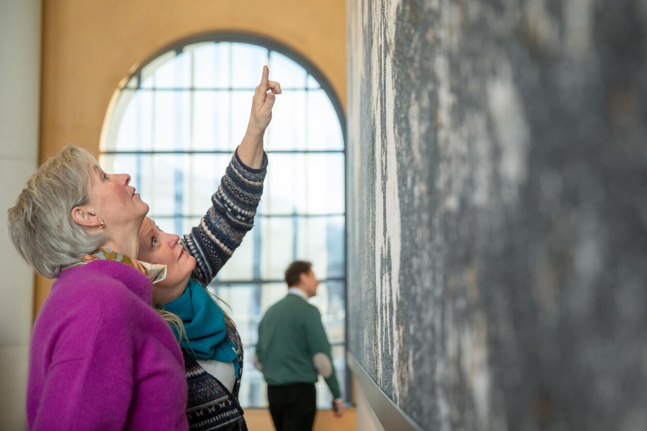 Scholars discussing in front of painting