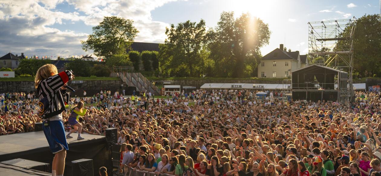 Bildet viser en musikkartist på scenen på Koengen i Bergen foran flere tusen studenter. 