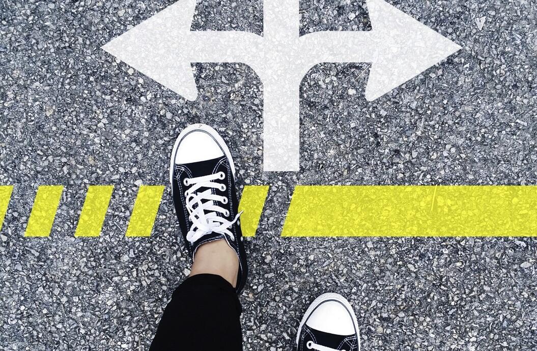 Feet on asphalt, arrows pointing in several directions