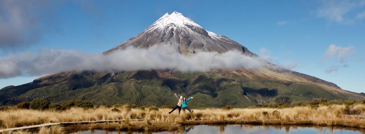 To studenter poserer foran vulkansk fjell på New Zealand