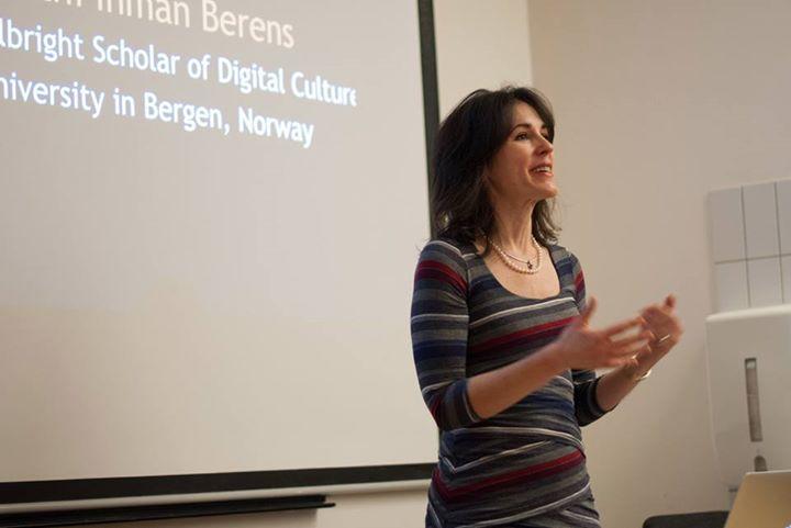 Kathi Inman Berens står foran et lerret og foreleser.