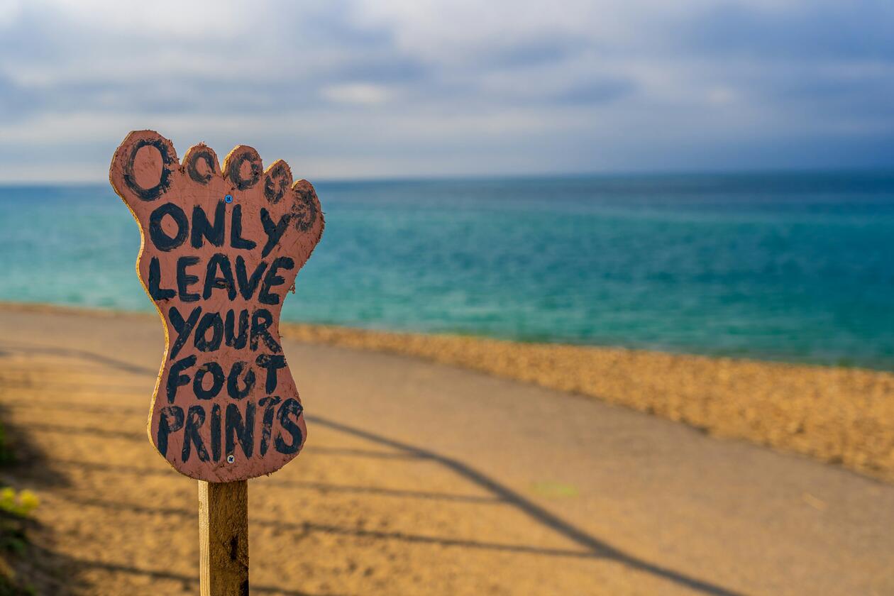 Beach with sign reading "only leave your footprints"