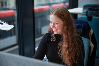 Bilde av Sigrid Clementine Kolbjørnsen sittende og jobbe ved et bord