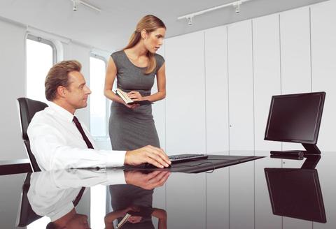 Photo showing two managers surfing the internet, used to illustrate an article on use of private social media at work.