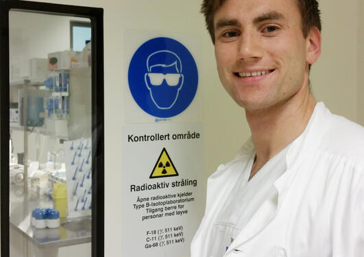 Farmasøyt Andreas Drangevåg utenfor område merket med advarsel mot radioaktiv stråling 