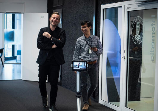 Media Futures christoff Trattner spaserer i gangen med robot