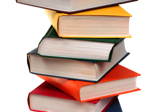 Bildet viser en stabel med fargerike bøker