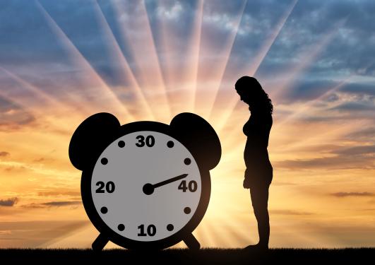 A woman standing by a clock