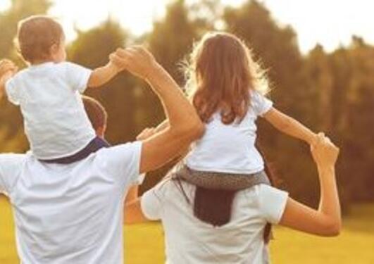 Two children sitting on their parent's shoulders