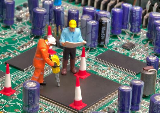 Mini workmen repairing a broken circuitboard