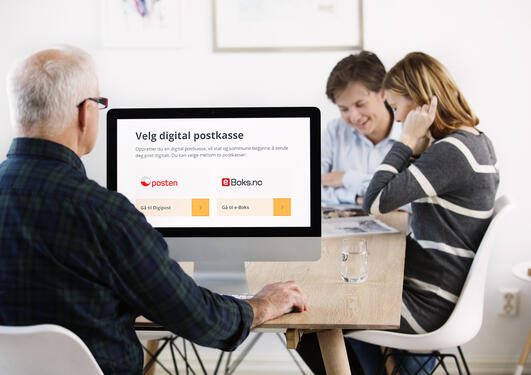 To personer som ser på en pc-skjerm med bilde av logoen til digital postkasse