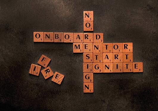 Scrabble biter som former ordene onboard, mentor, start
