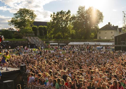 Bildet viser en musikkartist på scenen på Koengen i Bergen foran flere tusen studenter. 