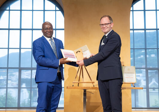 Prisvinner Achille Mbembe får Holbergprisen av Forsknings- og høyere utdanningsminister Oddmund Hoel (Sp)