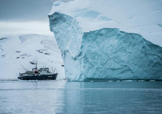 Iceberg with ship in Greenland