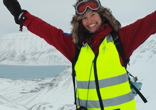 A lady in winter gear against arctic landscape