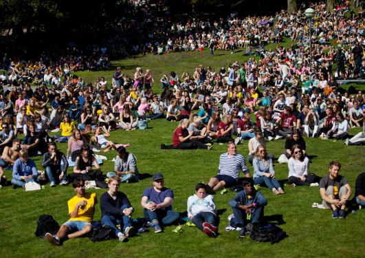 Mange studenter som sitter i solen i Nygårdsparken