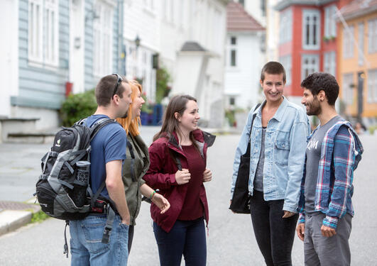 A group of students standing in the street, talking and smiling
