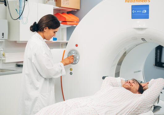 Karolina simulerer hvordan de utfører bildediagnostikk i PET/CT-scan på pasienter ved senter for nukleærmedisin/PET ved Haukeland Universitetssjukehus