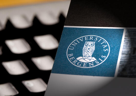 Keyboard and the UiB logo on paper