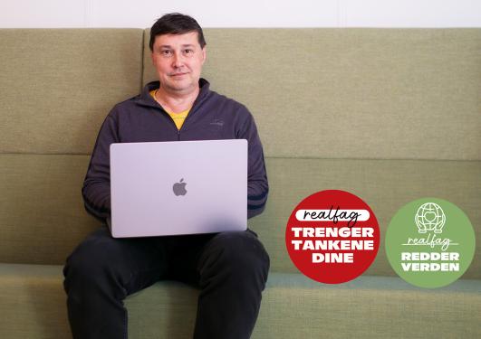 Førstelektor Oleksandr Kholosha ved Institutt for informatikk ved UiB sitter i en sofa med laptop på fanget. Spaltens faste logoer er i bildet.