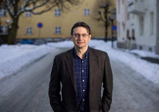 Scientist Sorin Bangu at the UiB Campus. Standing in the street and you can see parts of the yellow Sydneshaugen skole in the background