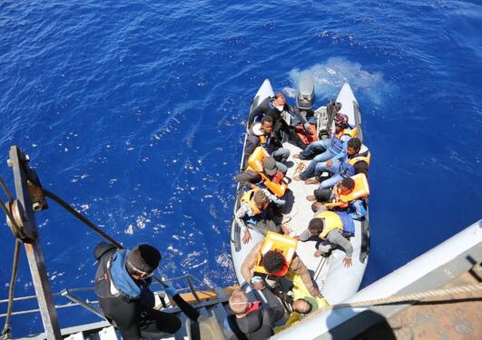 Migrants boarding a ship in the Mediterranean.