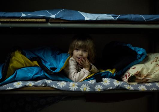 A child lies on a bed at a bomb shelter during an air raid alert in Zaporizhzhia, Ukraine.